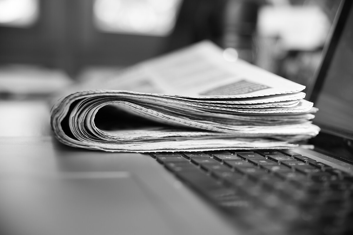 Eine Zeitung auf der Tastatur eines Laptops