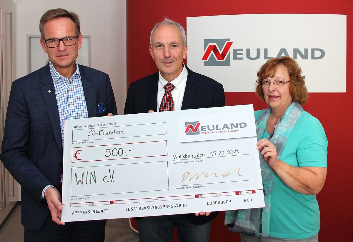Hans-Dieter Brand übergibt die Spende an Joachim Harms und Rita Rummrich von WIN e.V.
