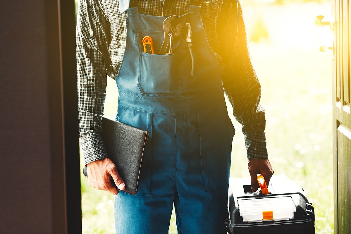 Ein Handwerker, der eine Wohnung betritt Ein Handwerker, der eine Wohnung betritt