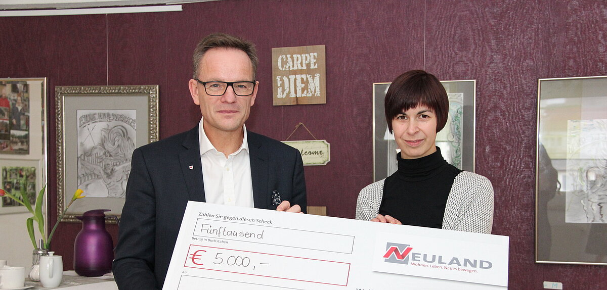 Herr Brand übergibt einen Spendenscheck an Carpe Diem